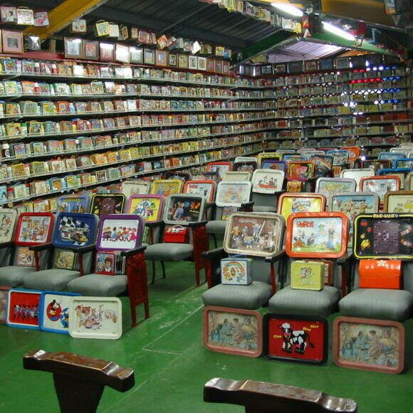 a room filled with lots of books and chairs in front of rows of bookshelves