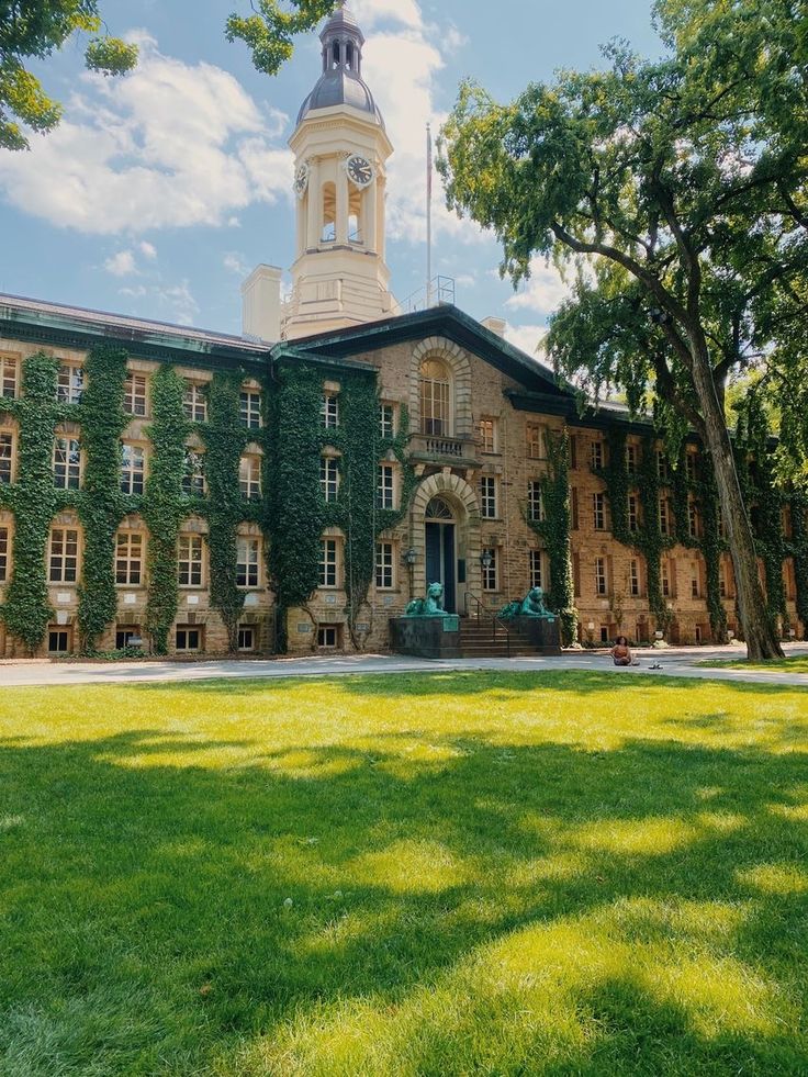 an old building with ivy growing on it's sides and a clock tower in the background