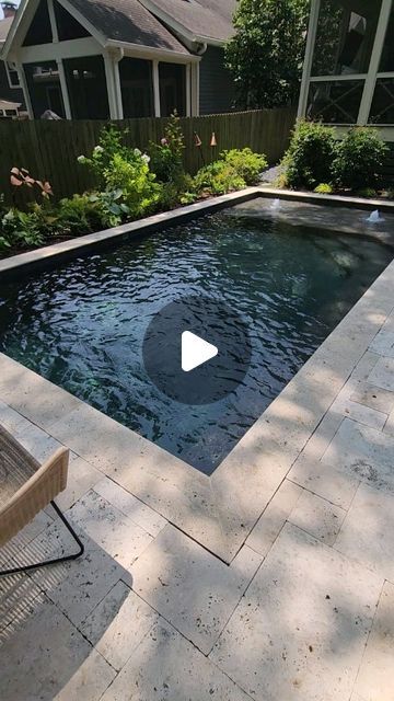 a backyard with a swimming pool surrounded by trees and bushes in the back yard area