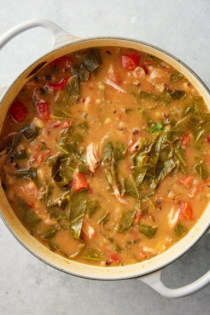 a pot filled with soup and vegetables on top of a table