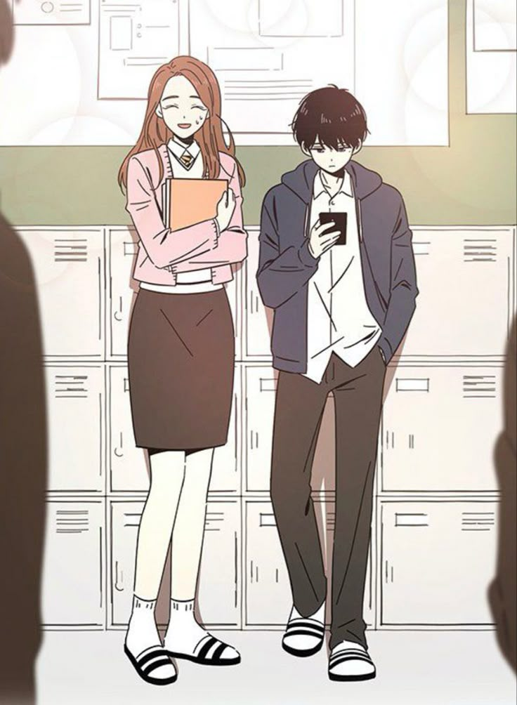 two people standing next to each other in front of lockers and looking at their cell phones