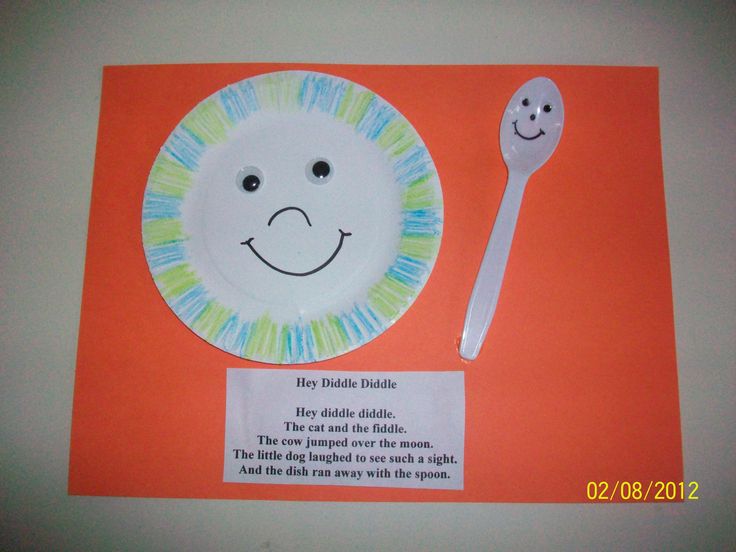 a paper plate with a smiley face on it next to a plastic spoon and fork