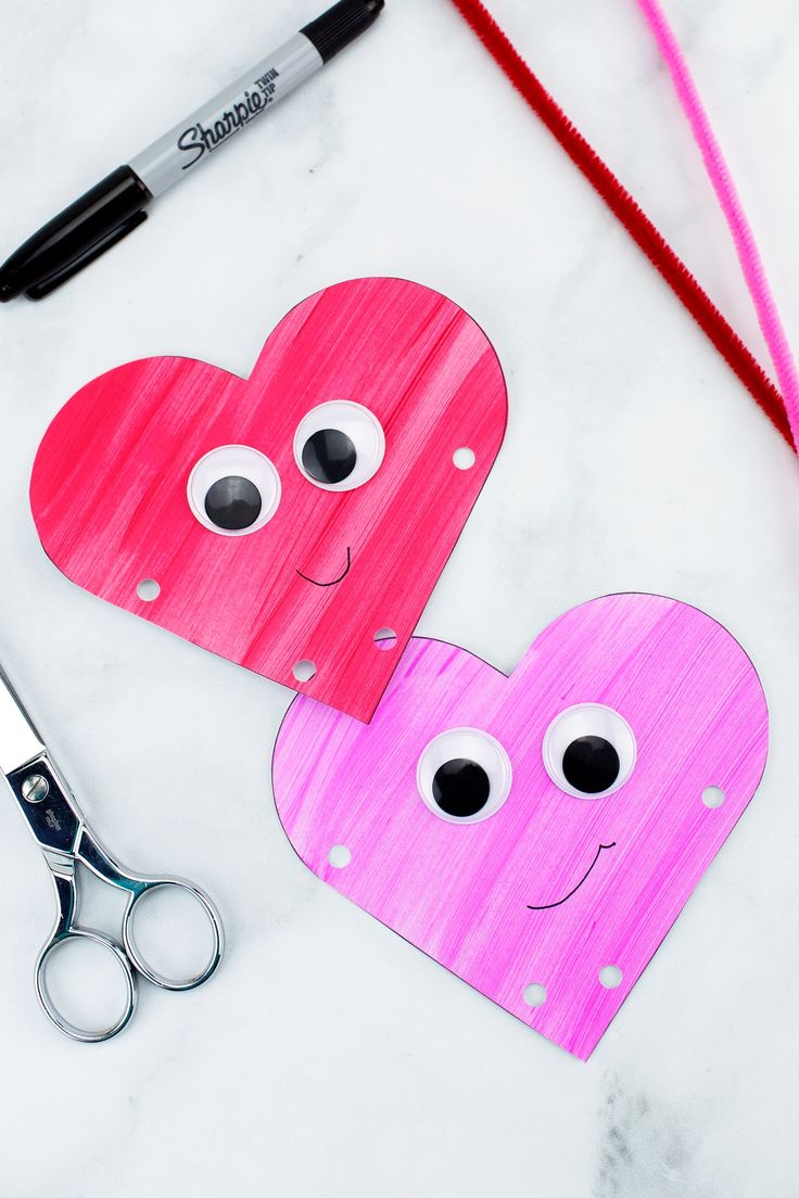 two paper hearts cut out to look like faces