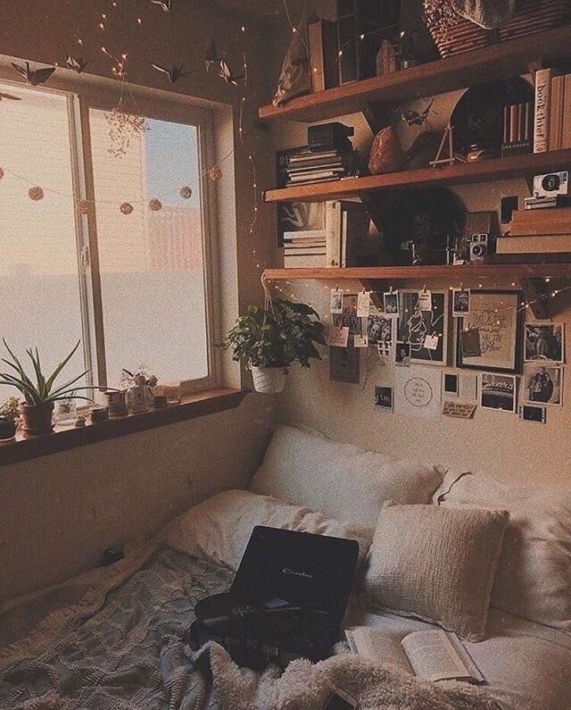 a laptop computer sitting on top of a bed in a room with lots of windows