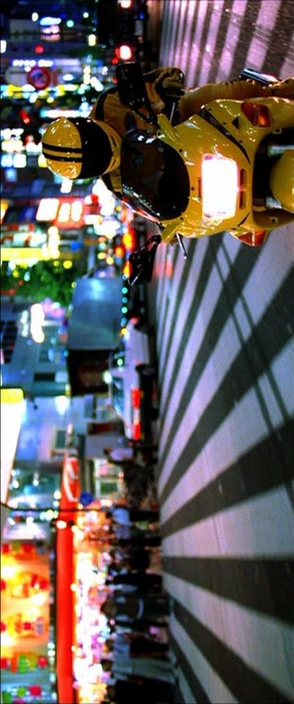 an overhead view of a city at night with traffic lights and buildings in the background