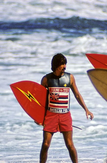 two surfers are standing in the water with their surfboards and one is holding his board