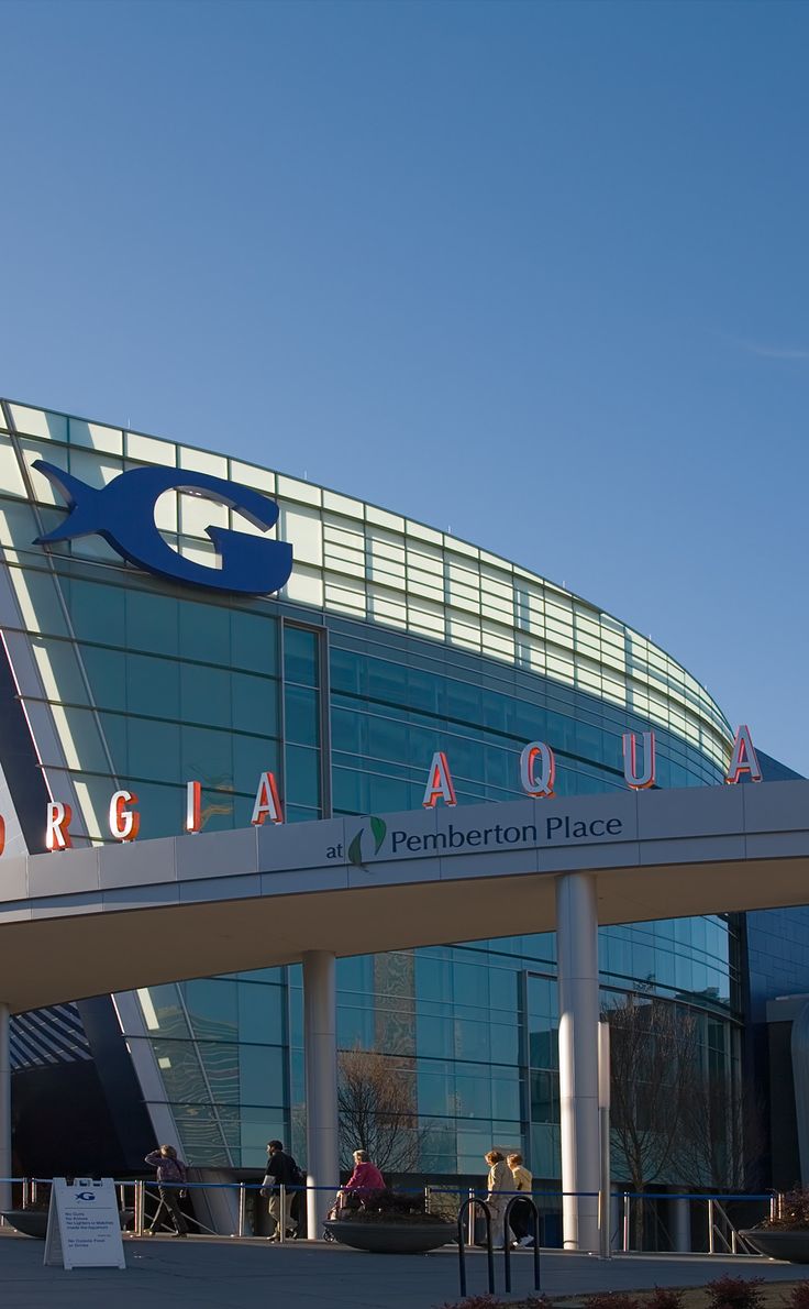 people are standing outside the front entrance of a large building with a sign that says georgia aquarium