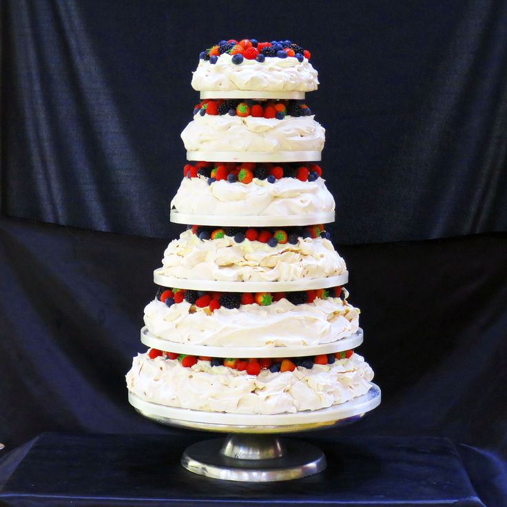 a triple layer cake with white frosting and multi colored candies on the top