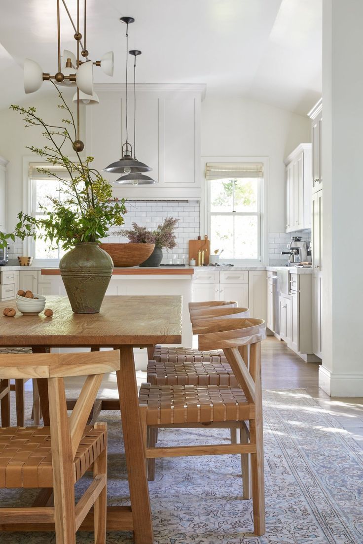 a wooden table sitting in the middle of a kitchen next to a potted plant