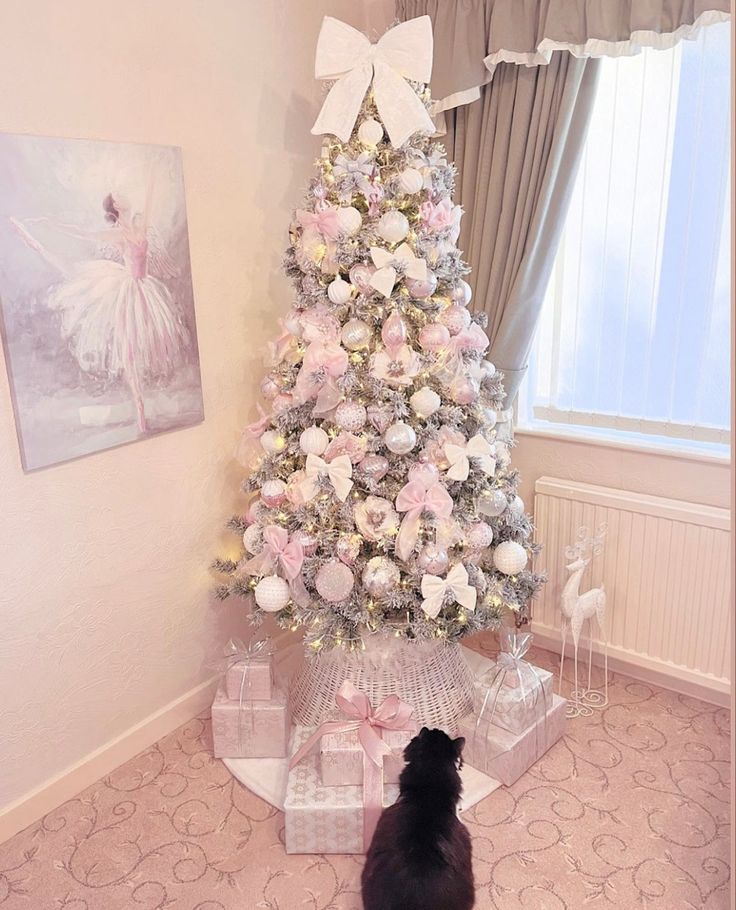 a white christmas tree with pink and silver decorations