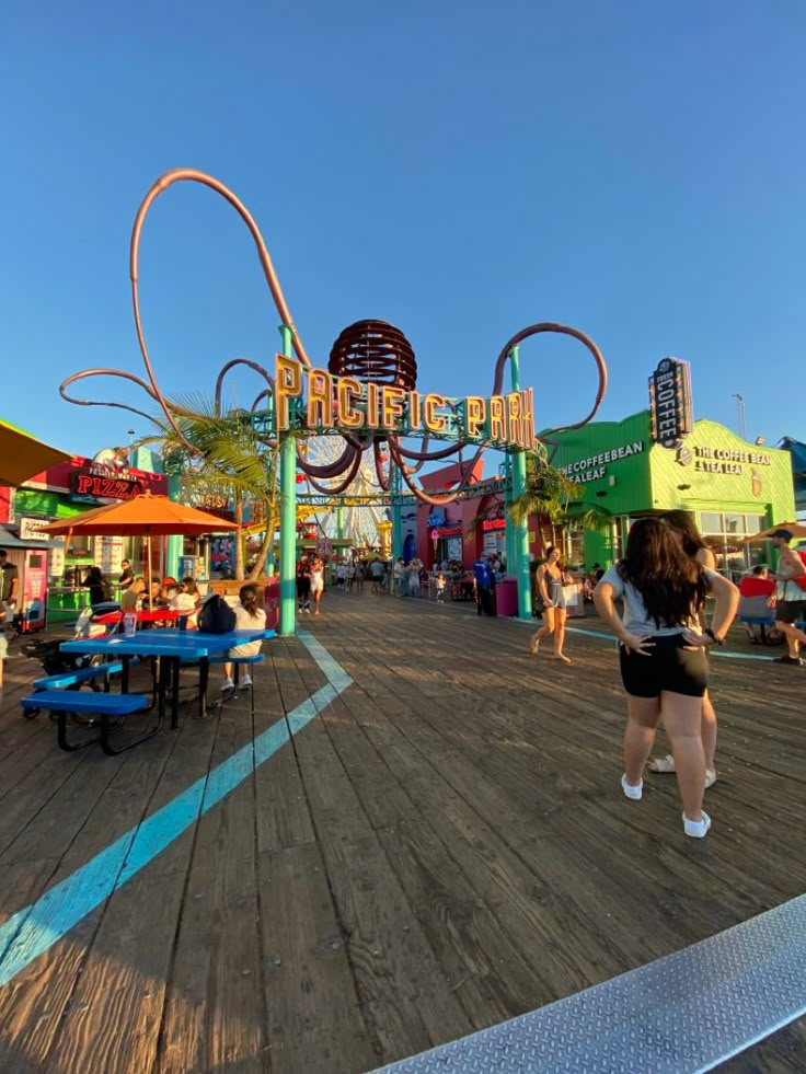 people are walking around an amusement park