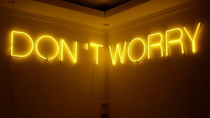 a neon sign that says don't worry on the wall