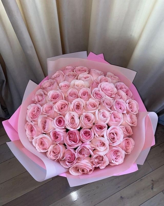 a large bouquet of pink roses sitting on top of a table