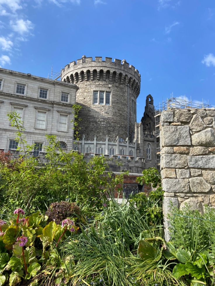 an old castle is surrounded by greenery and flowers