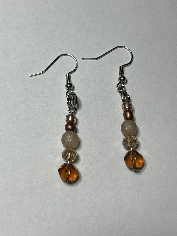 Orange and tan earrings perfect for any occasion! Beige Nickel Free Dangle Earrings, Beige Nickel-free Dangle Earrings, Nickel-free Beige Dangle Earrings, Elegant Beige Adjustable Beaded Earrings, Elegant Adjustable Beige Beaded Earrings, Beige Drop Earrings With Ear Wire, Beige Drop Earrings Gift Jewelry, Brown Nickel-free Dangle Beaded Earrings, Beige Drop Earrings As Gift