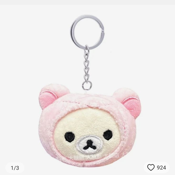 a pink teddy bear keychain with black eyes