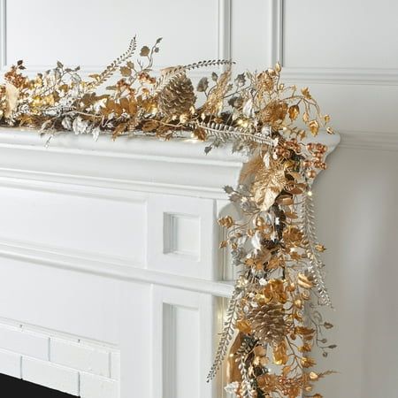 a gold and silver garland is hanging on the fireplace