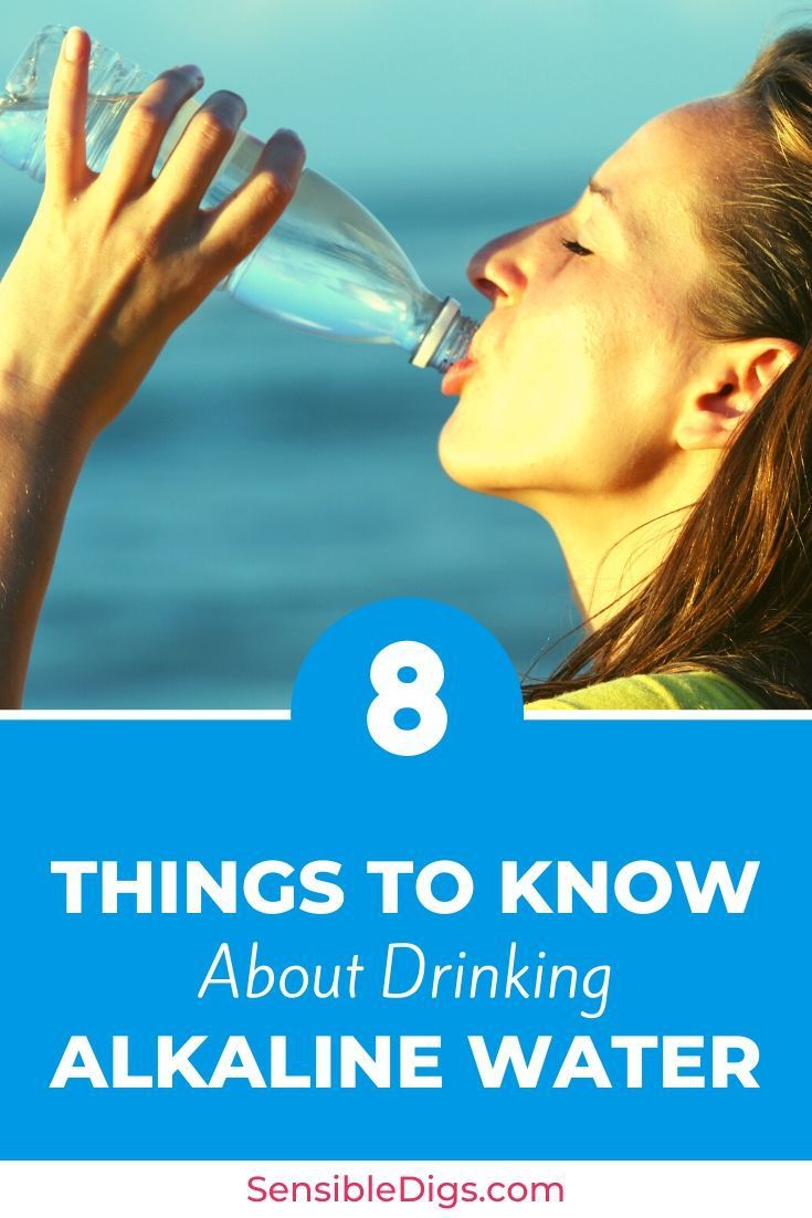 a woman drinking water from a bottle with the words 8 things to know about drinking alkaline water