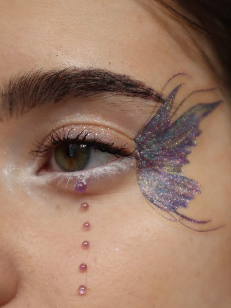 Glittery dreamy butterfly fairy wing eye makeup look Fairy Make Up Look Simple, Fairy Wings Eye Makeup, Fairy Eye Makeup Glitter, Butterfly Sticker Makeup, Fairy Butterfly Makeup, Fairy Wing Eye Makeup, Butterfly Wing Eye Makeup, Butterfly Temporary Tattoo Eye Makeup, Butterfly Wings Makeup