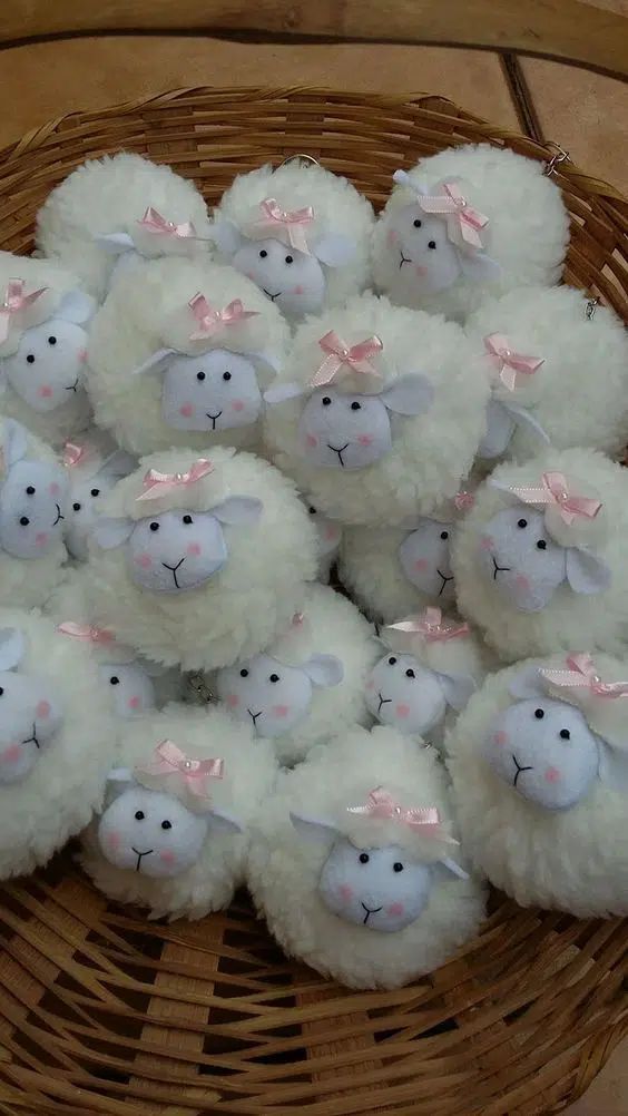 a basket filled with white stuffed sheep sitting on top of a table