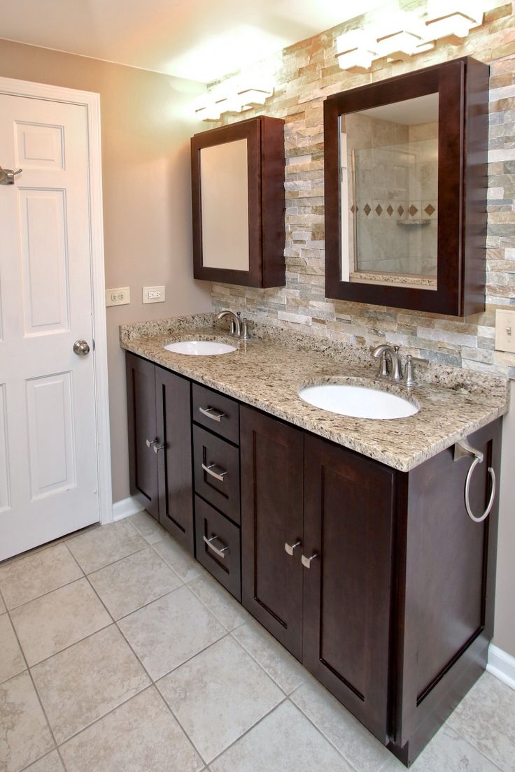 a bathroom with double sinks and two mirrors on the wall next to it's door