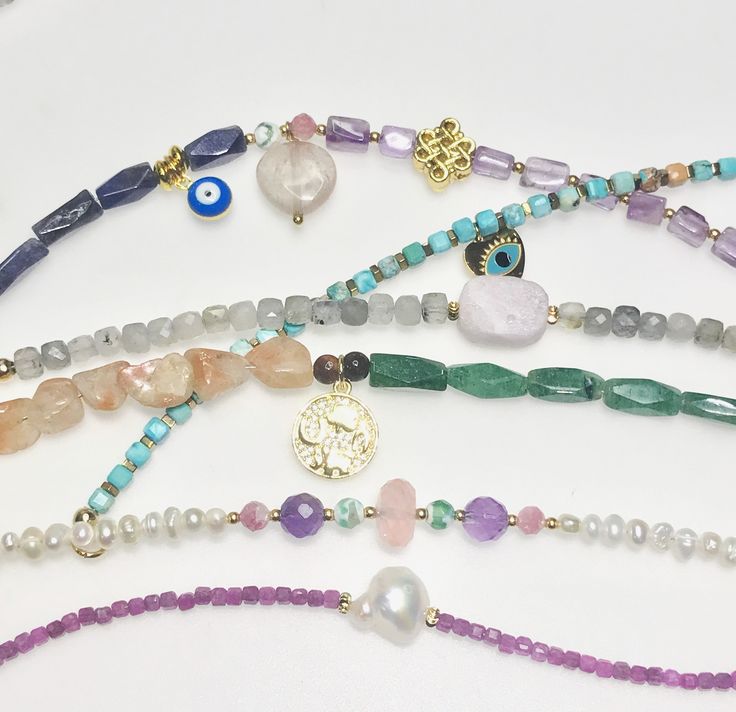 These power bead bracelets are lovely and  perfect to wear in stack as a single piece or wear in stack.Each stone has different meaning . 1. Heart , evil eye and Chinese infinity knot with Amethyst and blue facet Agate ( protection and forever love) 2.Kunzite  bead center with Labradorite cube shape  Kunzite will make you focus on what you need to do so that you can achieve anything that you want to while Labradorite will convey mysticism and courage. 3.Unusual shape freshwater pearl with 2mm. ruby beads Pearls also symbolize purity, as well as integrity and loyalty.While Ruby helps promote positive dreams and clear visualization and aid in retaining wealth and passion.  Size 18 cm.With 18 k gold plated lobster claw  Your bracelet will be packed nicely in  a pouch , ready to be a gift givi Evil Eye Bracelet With Round Gemstone Beads, Evil Eye Bracelet With Gemstone Beads As Gift, Gift Evil Eye Bracelet With Gemstone Beads, Spiritual Evil Eye Bracelet With Gemstone Beads As Gift, Heart Evil Eye, Coin Pearl Necklace, Different Meaning, Cube Shape, Infinity Knot