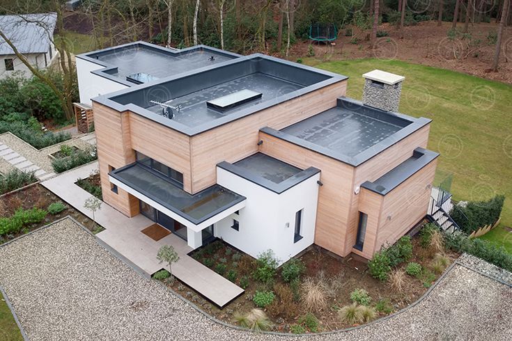 an aerial view of a modern house in the woods