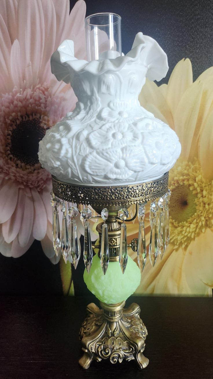 a white vase sitting on top of a table next to flowers