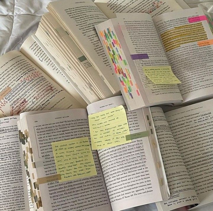 several open books with sticky notes on them