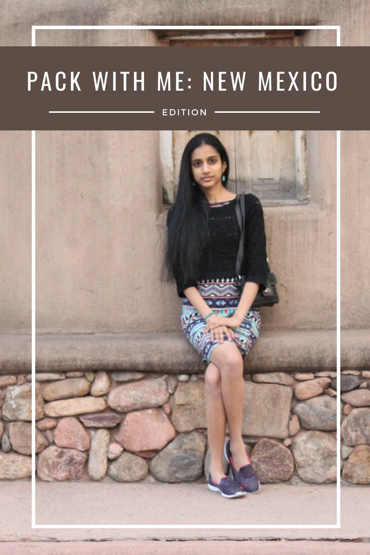 a woman sitting on top of a stone wall next to a window with the words pack with me new mexico