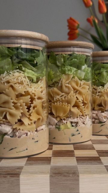 three glass jars filled with food on top of a checkered table