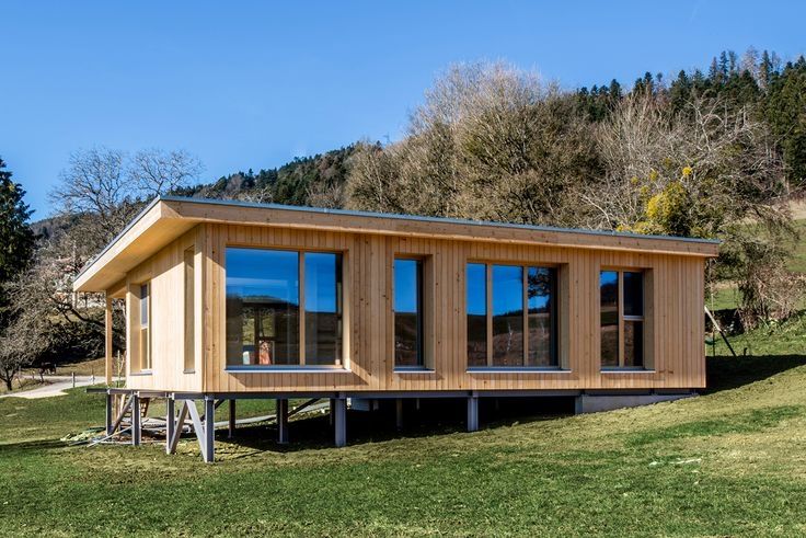 a small wooden cabin sitting on top of a lush green hillside