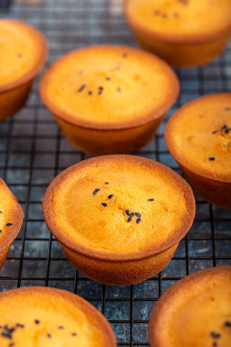 several muffins cooling on a wire rack with some black stuff in the middle