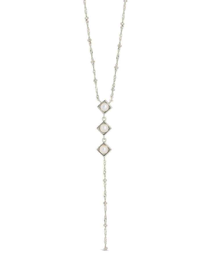 Introducing the Reine Lariat Necklace, a luxurious piece crafted for the sophisticated individual. This elegant necklace features a delicate beaded chain adorned with lustrous pearls, exuding an air of exclusivity and refinement. Elevate any outfit with the timeless style and grace of the Reine Lariat Necklace. Material: 14K gold or rhodium plated brass, freshwater pearls Features: Measures 16" with 2" extender, 3.75" drop, 0.35" pendants, 5mm pearls, 2mm chain, Lead & Nickel free, lobster clasp Lariat Necklace Silver, Pearl Lariat Necklace, Pearl Lariat, Gold Lariat Necklace, Elegant Necklace, Pearl Earrings Dangle, Elegant Necklaces, Style And Grace, Sterling Silver Hoops