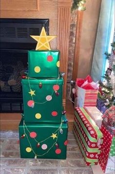 three stacked christmas presents sitting in front of a fire place with a star on top