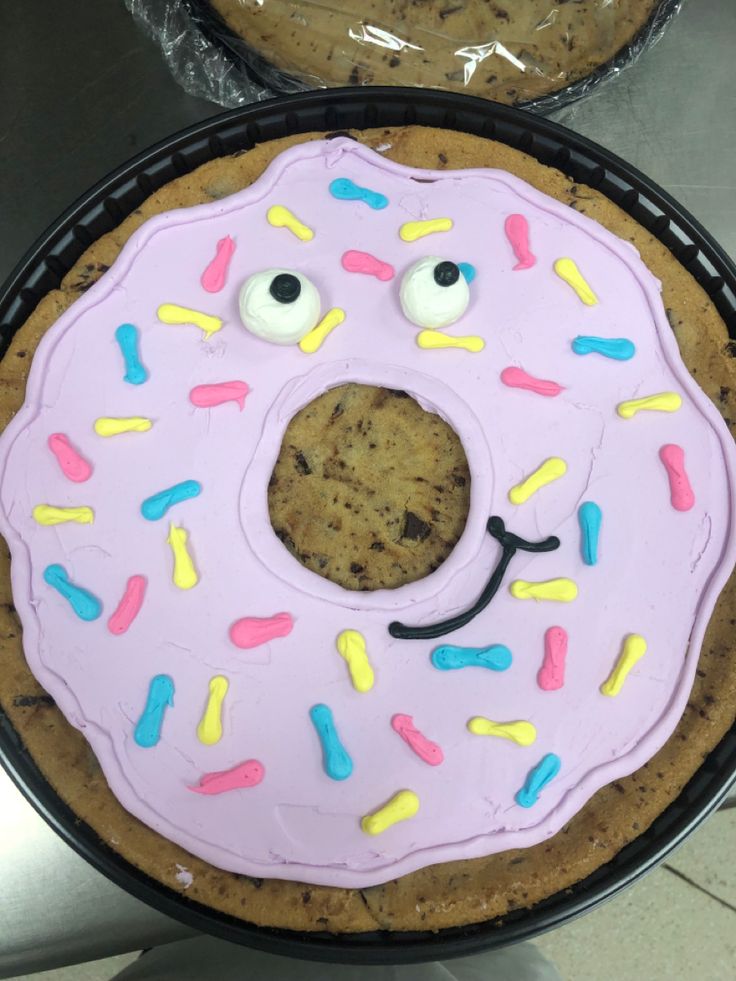 there is a cake shaped like a doughnut with eyes and mouth on the plate