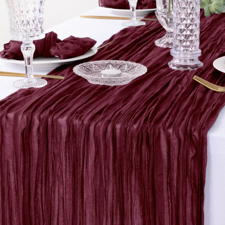 the table is set with wine colored linens