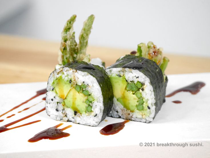 two sushi rolls with avocado, cucumber and sauce