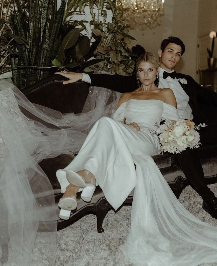 a bride and groom sitting on a couch