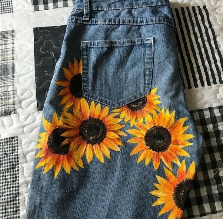 a pair of jeans with sunflowers painted on them