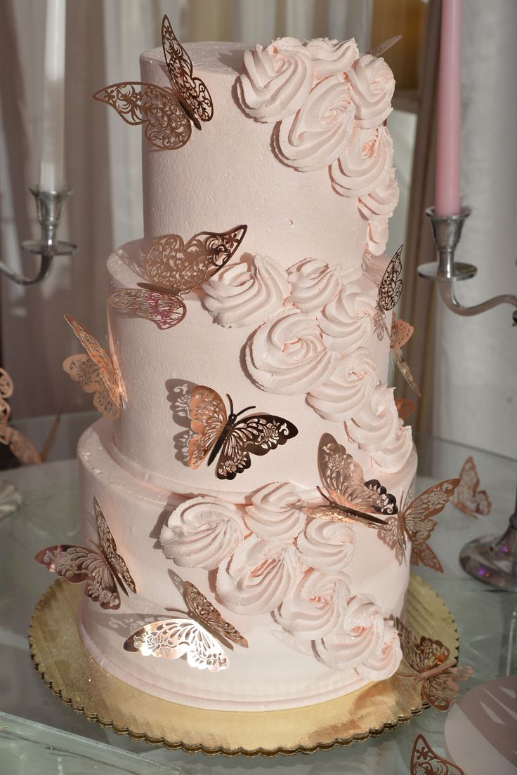 a three tiered cake with butterflies on it