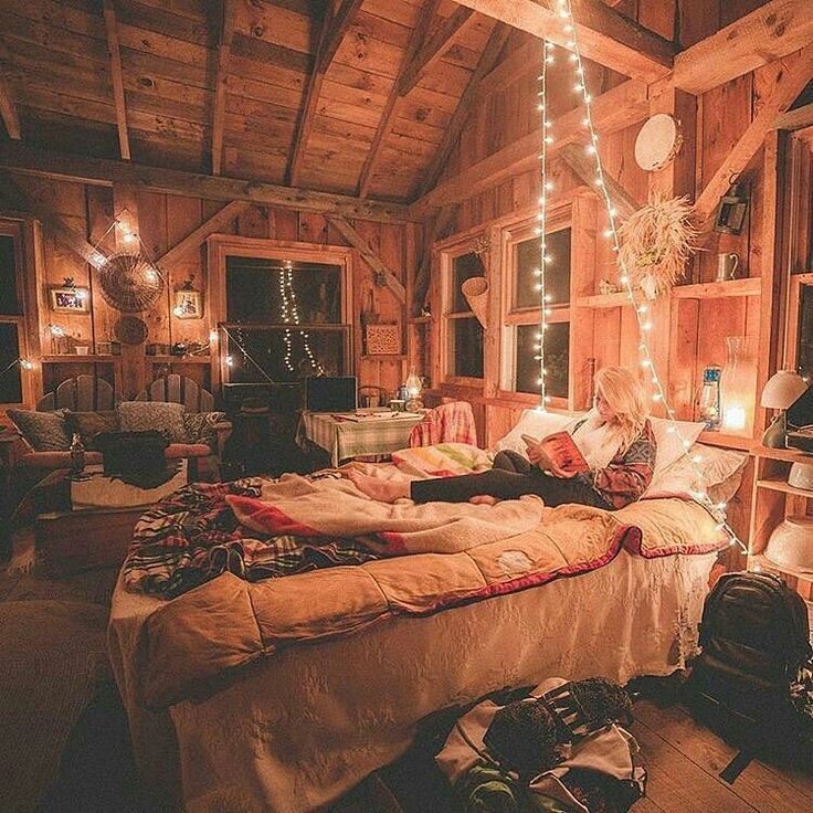 a bed room with a neatly made bed and lots of lights hanging from the ceiling