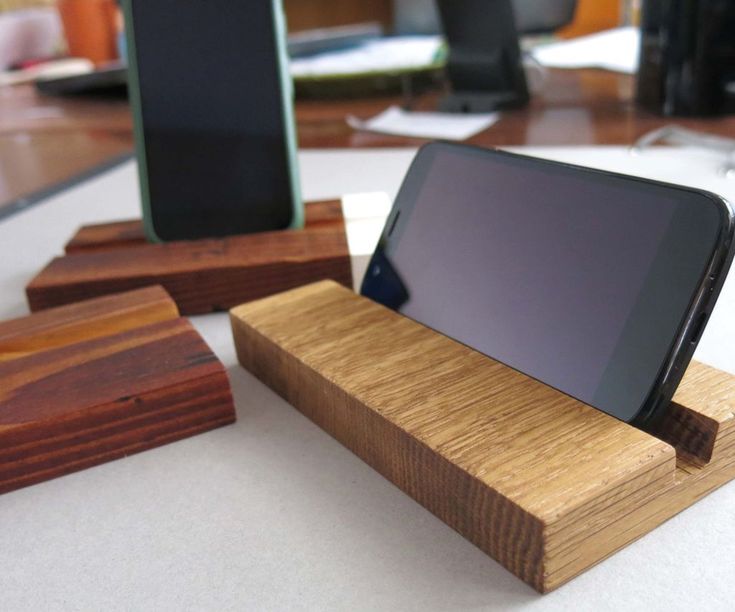 a cell phone sitting on top of a wooden docking dock next to two other phones