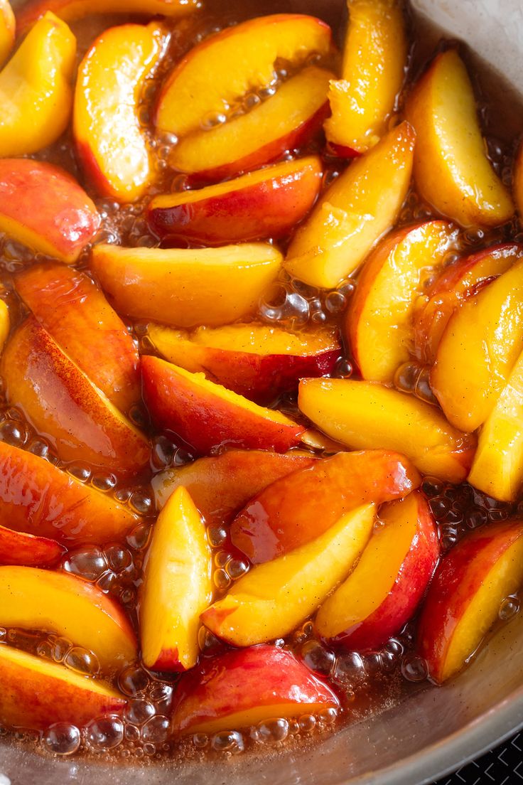 sliced peaches and nectarines in a pan with water on the stove burner