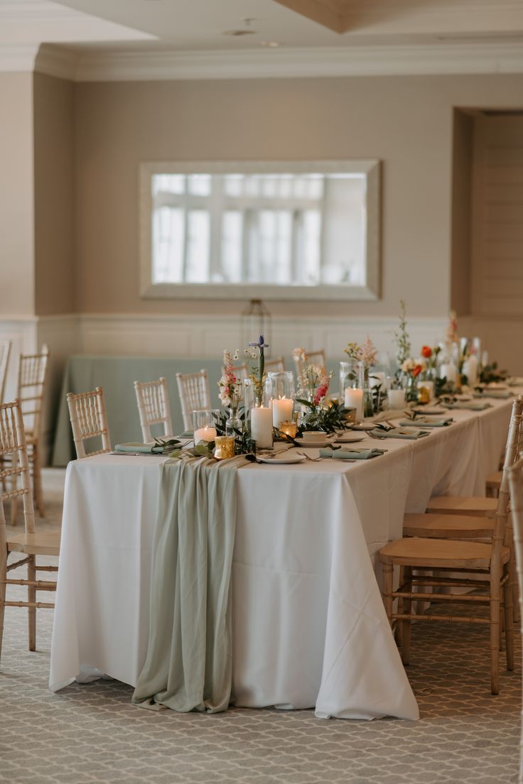 the table is set with candles, flowers and napkins for an elegant wedding reception