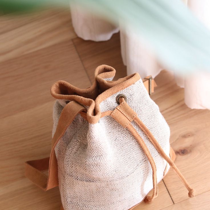 This handy drawstring bucket bag is a perfect fusion of traditional weaving with modern style. It is an easy and playful bag to store quite a bit. The shoulder straps and closures are made of suede leather with a beautiful finish. The bag closes by pulling the cord, like a pouch bag. This lightweight and body-friendly bag can be worn cross-body or over the shoulder with a long or short drop, thanks to its adjustable strap. The sturdy bottom base is slightly smaller while wider upwards, making it Natural Bucket Bag With Leather Handles For On-the-go, Bucket Pouch Bag With Braided Handles For Errands, Daily Use Tote Drawstring Bag With Adjustable Strap, Daily Use Drawstring Tote Bag With Adjustable Strap, Everyday Drawstring Tote Bag With Adjustable Strap, Eco-friendly Beige Pouch Bucket Bag, Everyday Drawstring Shoulder Bag With Adjustable Strap, On-the-go Natural Bucket Bag With Leather Handles, Eco-friendly Crossbody Bucket Bag For Daily Use