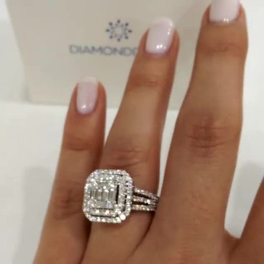 a woman's hand with a diamond ring on top of her finger and a box behind her