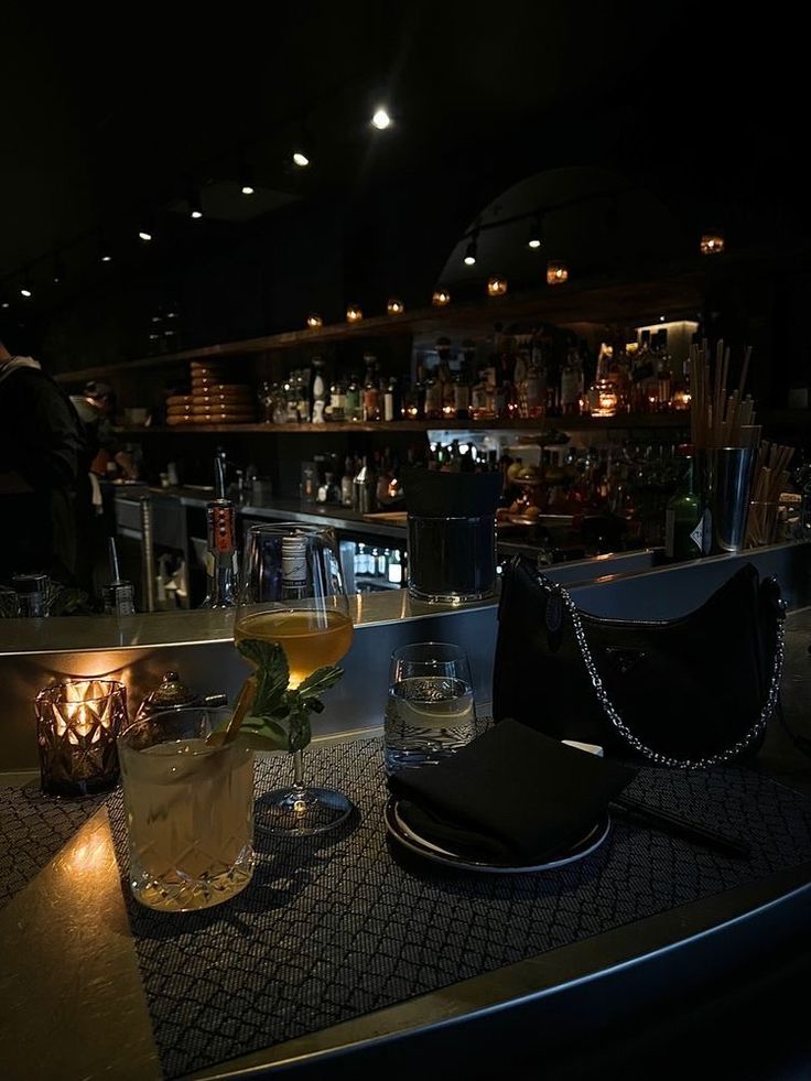 a dimly lit bar with drinks on the counter