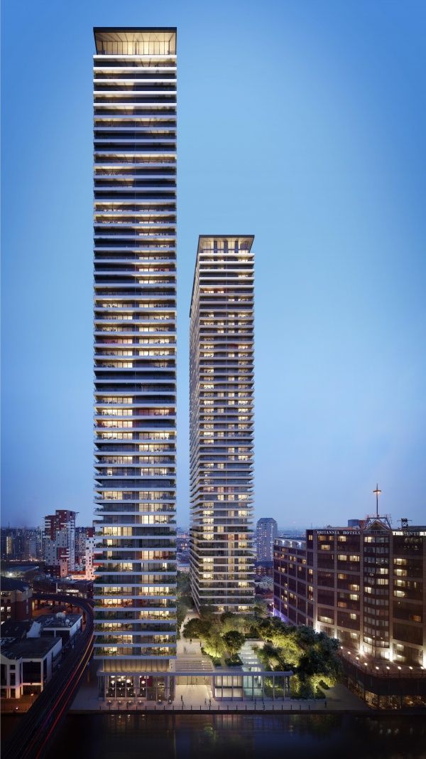 two tall buildings next to each other in front of a cityscape at night