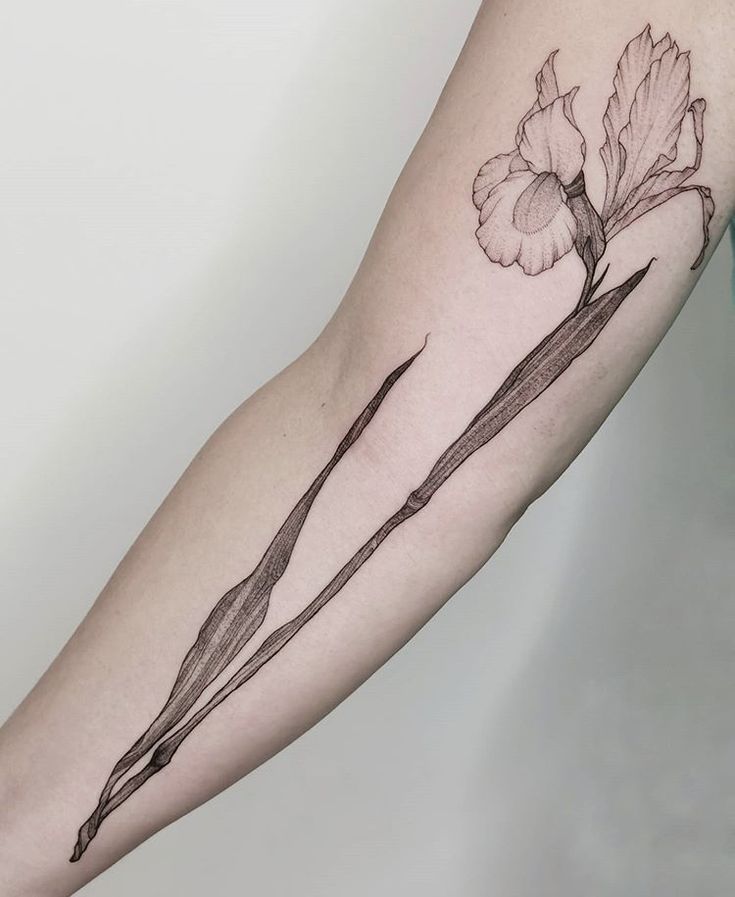 a woman's arm with a flower tattoo on it